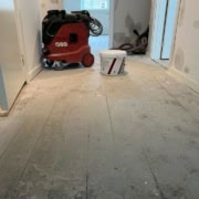 Gang under renovering med støvet gulv.