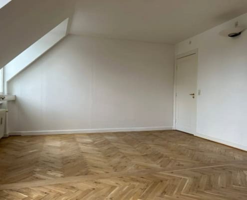 Hvidt værelse med skråvægge.