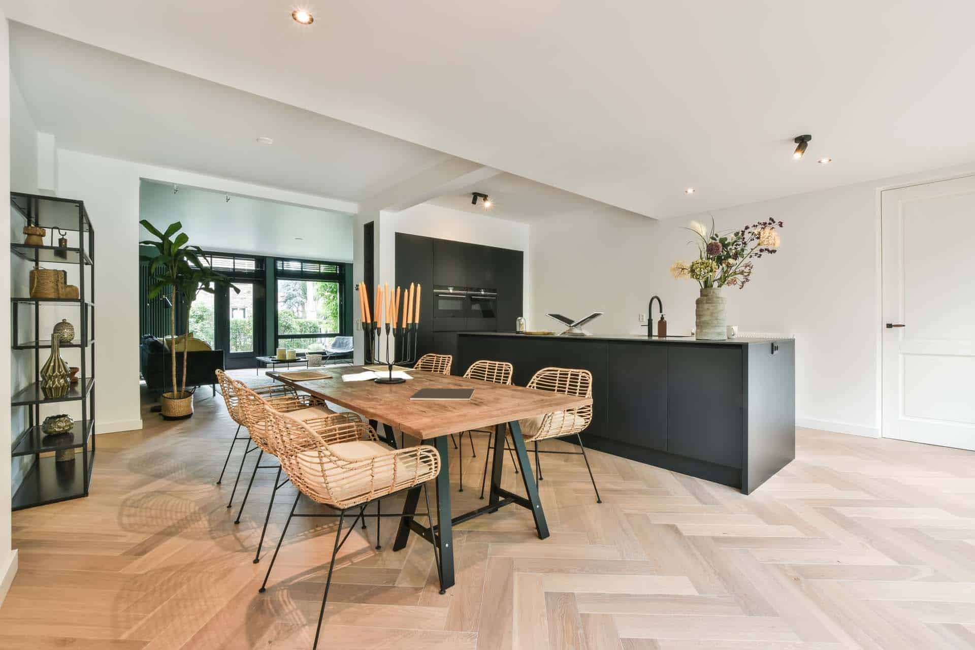 Lys stue med køkken i sort. Træ spisebord og stole.