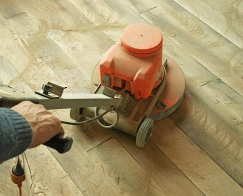 Plankegulv med en rød gulvsliber ovenpå.